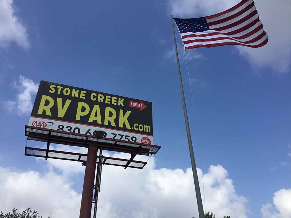 The front entrance sign and American flag at STONE CREEK RV PARK