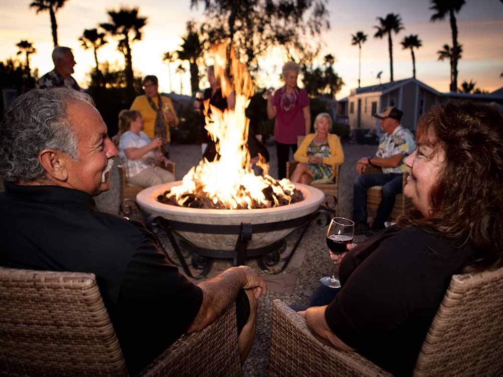 Guests enjoying the evening in front of a fire pit at GOLD CANYON RV & GOLF RESORT