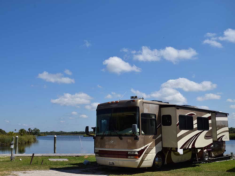 A Class A motorhome by the water at NATURE'S RESORT