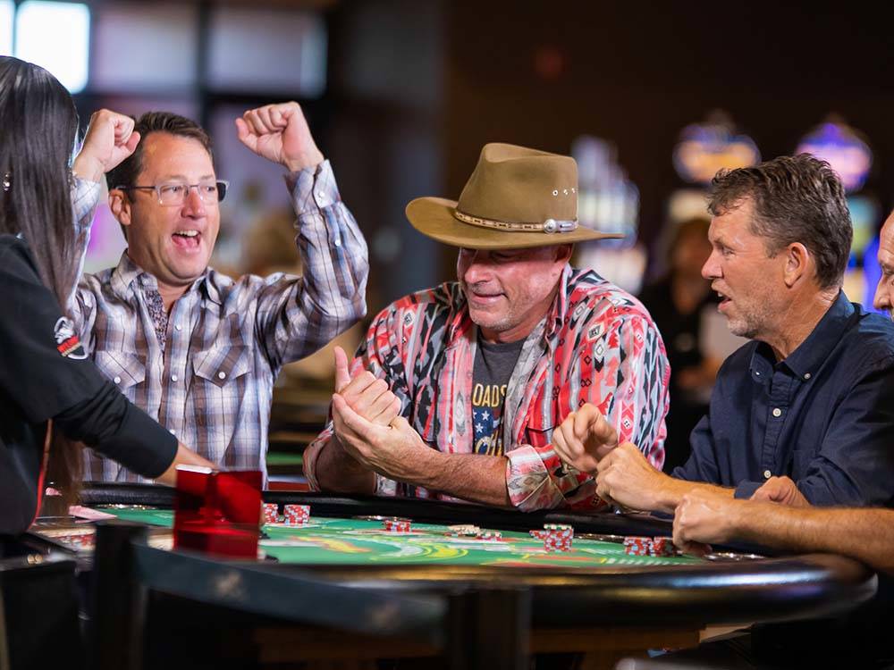 A man cheering on a winner at a card table at WILDHORSE RESORT & CASINO RV PARK