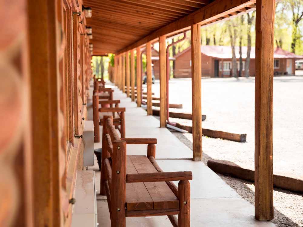 A row of wooden benches under an awning at THE LONGHORN RANCH LODGE AND RV RESORT