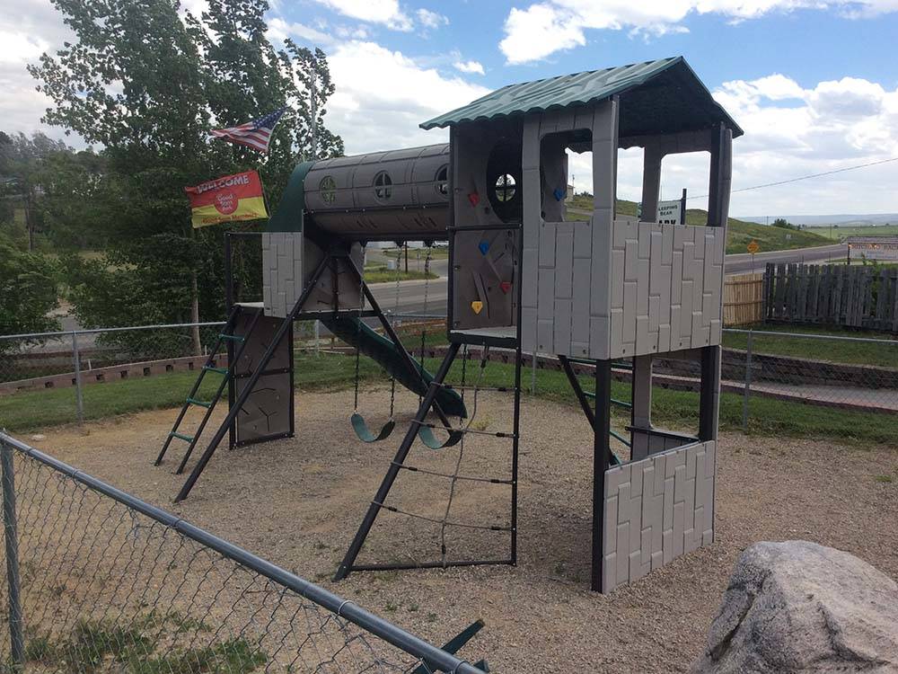 Playground area with swings and slide at SLEEPING BEAR RV PARK & CAMPGROUND