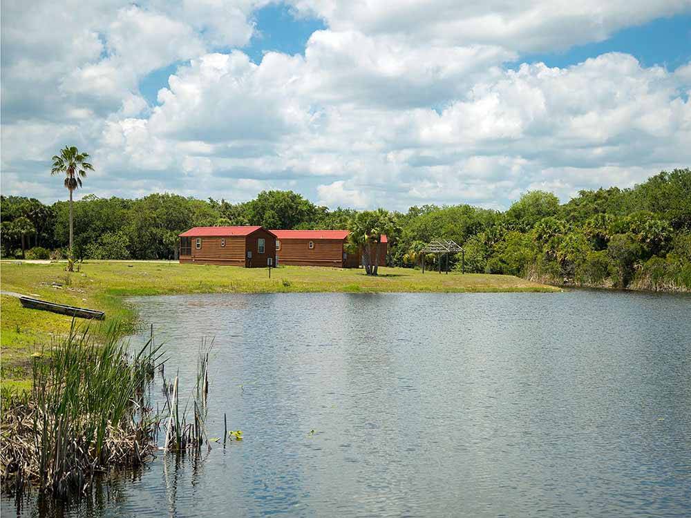 A group of rental cabins by the water at BIG CYPRESS RV RESORT