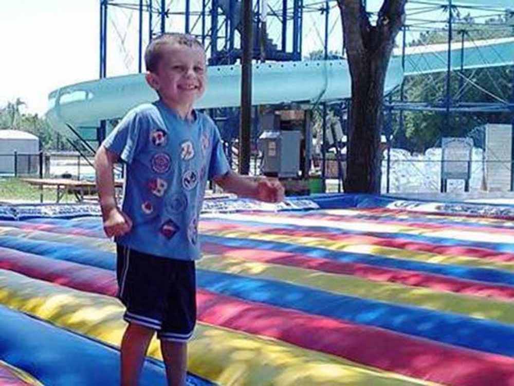 Boy smiling on jump pad at RAGANS FAMILY CAMPGROUND