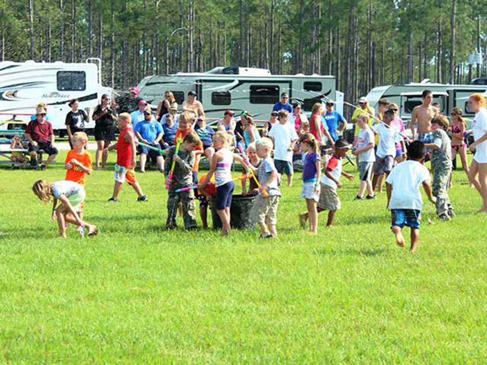 Several children playing with toys on lush lawn at RAGANS FAMILY CAMPGROUND
