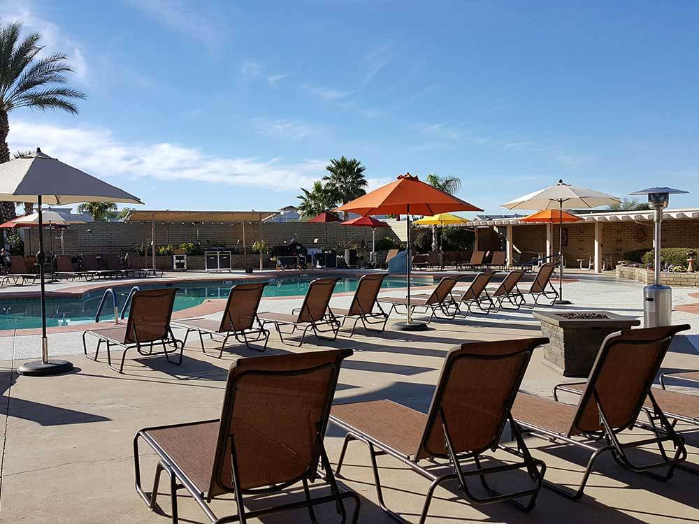 Swimming pool with outdoor seating and orange umbrellas at FAR HORIZONS RV RESORT