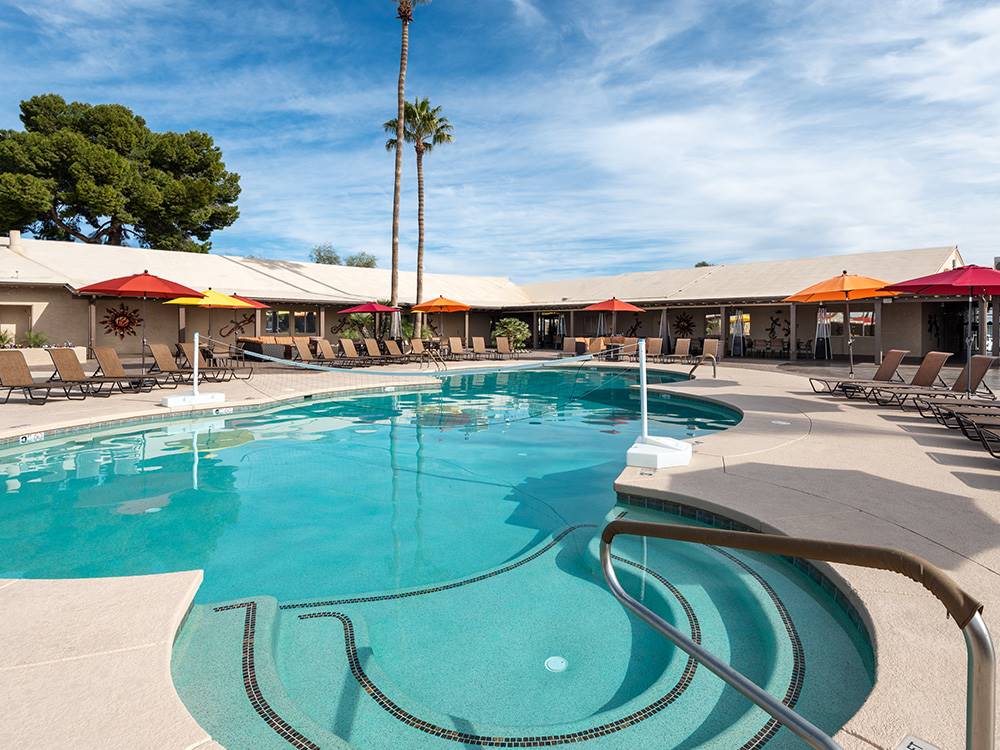 Swimming pool with outdoor seating and orange umbrellas at FAR HORIZONS RV RESORT