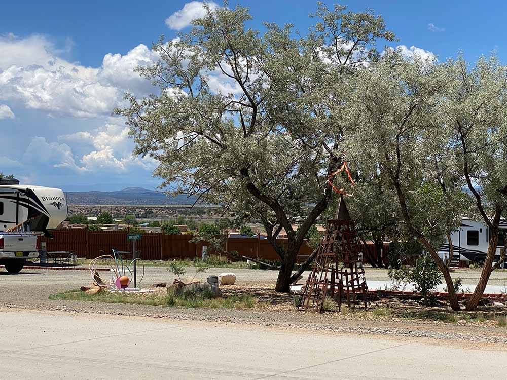 A couple of trees next to a RV site at SANTA FE SKIES RV PARK
