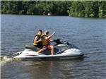 Dad and son on a water craft on the lake at LAKE GASTON AMERICAMPS - thumbnail