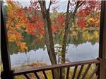 Balcony overlooks a placid lake reflecting autumn trees at PINE LAKE RV RESORT & COTTAGES - thumbnail