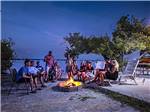 Group of campers enjoying an evening outdoors with campfire at BOYD'S KEY WEST CAMPGROUND - thumbnail