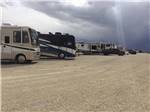A row of motorhomes in gravel at WESTERN HILLS CAMPGROUND - thumbnail