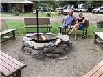 A couple sitting around a fire pit at WOLF LODGE CAMPGROUND - thumbnail