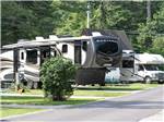 Fifth wheels and trailers parked in paved sites at FIELD & STREAM RV PARK - thumbnail