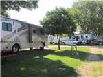 White and grey motorhome parked near brown park bench at HOLIDAY RV PARK & CAMPGROUND - thumbnail