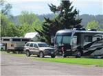Motorhome, trailer and SUVs parked at RV park at HAPPY HOLIDAY RV RESORT - thumbnail