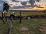 Cannon pointing to expansive field at dusk at GETTYSBURG CAMPGROUND - thumbnail