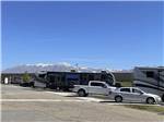 A row of RV sites with mountains in the background at CENTURY RV PARK & CAMPGROUND - thumbnail