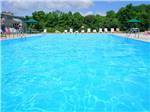 Swimming pool with lounge chairs at AMERICAN HERITAGE RV PARK - thumbnail