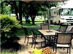 A patio table next to an RV site at AMERICAN HERITAGE RV PARK - thumbnail