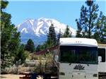 Motorhome in camp with mountain in background at FRIENDLY RV PARK - thumbnail