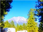 Mountain looms over RVs in camp at FRIENDLY RV PARK - thumbnail