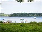 Kayaks and boat on the lake with bicycles on lake's edge at PATTEN POND CAMPING RESORT - thumbnail