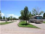 A motorhome parked in a gravel pull thru site at SUNNY ACRES RV PARK - thumbnail