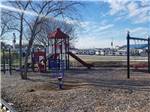 Brightly colored playground with slide and swings at CAMPING WORLD RACING RESORT - thumbnail