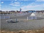 Roadway leading through parking lot of raceway with white fencing along both sides at CAMPING WORLD RACING RESORT - thumbnail