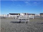 Picnic table on gravel with white fencing and large raceway in background at CAMPING WORLD RACING RESORT - thumbnail