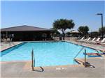 Swimming pool with lounge chairs at FUN TOWN RV PARK AT WINSTAR - thumbnail