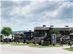 A row of Motorhomes parked in concrete sites at FUN TOWN RV PARK AT WINSTAR - thumbnail