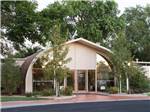 Arching brown and tan community building with glass entry doors at CORONADO VILLAGE RV RESORT - thumbnail