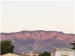 Rooftops with red desert mountains in background at CORONADO VILLAGE RV RESORT - thumbnail