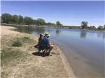 People sitting in chairs fishing at I-80 LAKESIDE CAMPGROUND - thumbnail