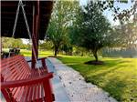 A bench swing looking at a greenery area at RED GATE FARMS - RV RESORT - thumbnail