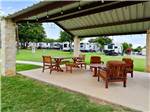 Wooden bench and table with chairs under the pavilion at NORTHLAKE VILLAGE RV PARK - thumbnail
