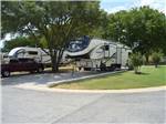 Trailers parked in sites with trees at NORTHLAKE VILLAGE RV PARK - thumbnail