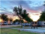 A row of paved RV sites at dusk at KEARNEY RV PARK & CAMPGROUND - thumbnail