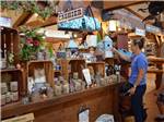 A woman shopping for candles in the general store at CAMP TURKEYVILLE RV RESORT - thumbnail