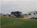 RVs on a road flanked by grassy areas at CAMPLAND RV RESORT - thumbnail