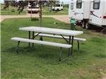 Picnic table on grass outside of RV at CAMPLAND RV RESORT - thumbnail