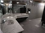 Bathroom with gray tiles and two sinks at CAMPLAND RV RESORT - thumbnail