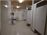 Bathroom with stalls and clean floor at CAMPLAND RV RESORT - thumbnail