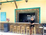 A woman in leopard pants standing in front of the snack bar at SANDPIPER RV RESORT - thumbnail