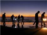 A group of people digging for clams at dusk at OCEAN PARK RESORT - thumbnail