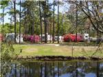 View of RVs near the water at WHISPERING PINES CAMPGROUND - thumbnail