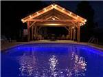 Pool at night near an a-frame canopy at RUSTIC MEADOWS RV PARK - thumbnail