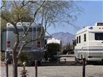 Two motorhomes parked in gravel sites at CRAZY HORSE RV CAMPGROUNDS - thumbnail